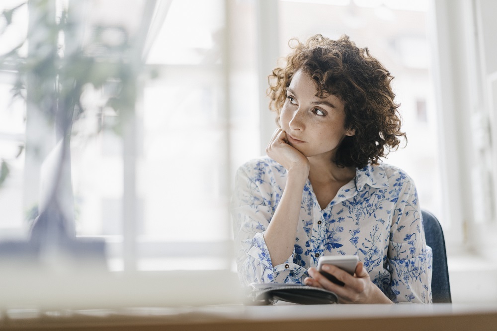 On-page, 2024. A woman looking throughtfully to the side in a sunny room at home.